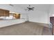 View of an open concept living room with a brick fireplace and a view into the kitchen at 1913 Piccolo Way, Las Vegas, NV 89146