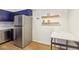 Bright kitchen with stainless refrigerator, wooden shelves, and breakfast nook area at 2128 Petersham Ct # C, Las Vegas, NV 89108