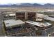 Aerial view showcasing the resort's exterior, parking, and the surrounding urban landscape against a backdrop of mountains at 2208 Spring Water Dr, Las Vegas, NV 89134