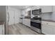 Updated kitchen with stainless steel appliances, white cabinets, and wood-look flooring at 2208 Spring Water Dr, Las Vegas, NV 89134