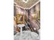 Elegant powder room featuring marble floors, patterned wallpaper, and gold-framed art at 2209 Glenbrook Way, Las Vegas, NV 89117