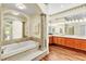 Primary bathroom featuring a soaking tub, hardwood floors, and dual sink vanity at 2209 Glenbrook Way, Las Vegas, NV 89117