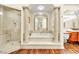 Luxurious bathroom with soaking tub, glass shower, and wood floors at 2209 Glenbrook Way, Las Vegas, NV 89117