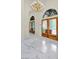 Bright foyer featuring a high ceiling, marble floors, and beautiful double doors with glass panels and gold chandelier at 2209 Glenbrook Way, Las Vegas, NV 89117