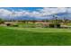 Scenic golf course featuring lush green fairways, a tranquil pond, and stunning mountain backdrop at 2209 Glenbrook Way, Las Vegas, NV 89117