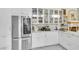 Bright, white kitchen featuring modern appliances, marble countertops, and glass cabinet doors for elegant storage at 2209 Glenbrook Way, Las Vegas, NV 89117