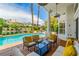 Covered patio with comfortable seating, offering picturesque views of the pool, lush landscaping, and the surrounding neighborhood at 2209 Glenbrook Way, Las Vegas, NV 89117