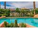 Beautiful pool surrounded by lush landscaping and desert plants with neighborhood homes in the background at 2209 Glenbrook Way, Las Vegas, NV 89117