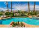 A luxurious pool featuring rock details, lush landscaping, and views of other luxurious houses across the pond at 2209 Glenbrook Way, Las Vegas, NV 89117