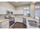 Modern kitchen featuring stainless steel appliances, granite counters, and custom cabinetry at 2330 Spring Water Dr, Las Vegas, NV 89134