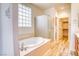 Bathroom featuring a soaking tub, glass enclosed shower, and tile flooring at 2383 Rainswept Ave, Henderson, NV 89052