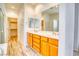 Bathroom featuring double sinks, wooden cabinets, and an open closet at 2383 Rainswept Ave, Henderson, NV 89052