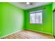A bedroom with green walls, wood floor, and a window with a view to the outside at 2383 Rainswept Ave, Henderson, NV 89052