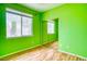 A bedroom with green walls, wood floors, and a mirrored closet door at 2383 Rainswept Ave, Henderson, NV 89052