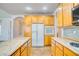 Bright kitchen featuring wood cabinetry, tile floors, stainless steel appliances, and an island at 2383 Rainswept Ave, Henderson, NV 89052