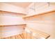 A walk-in closet with wooden shelving and a built-in bench at 2383 Rainswept Ave, Henderson, NV 89052