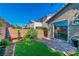 Cozy backyard featuring a stone patio, small lawn, privacy wall, and mature plants, perfect for relaxing outdoors at 2409 Cockatiel Dr, North Las Vegas, NV 89084