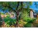 Inviting backyard with lush lawn, mature trees, and a charming brick patio area at 2409 Cockatiel Dr, North Las Vegas, NV 89084
