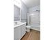 Clean bathroom with a white vanity, wood-look floors, and a shower-tub combination at 2409 Cockatiel Dr, North Las Vegas, NV 89084