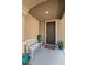 Welcoming front porch with a cozy bench and decorative plants, enhancing curb appeal at 2409 Cockatiel Dr, North Las Vegas, NV 89084