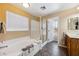 Bathroom featuring a soaking tub, glass-enclosed shower, and a single sink vanity at 248 Hyssop Ct, Henderson, NV 89015
