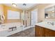 Bathroom featuring a soaking tub, glass-enclosed shower, and a single sink vanity at 248 Hyssop Ct, Henderson, NV 89015