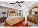 Comfortable main bedroom featuring a tray ceiling, ceiling fan, and an adjacent ensuite bathroom at 248 Hyssop Ct, Henderson, NV 89015