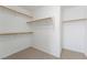 Walk-in closet featuring carpeted floors and wooden rails and shelves for ample storage at 248 Hyssop Ct, Henderson, NV 89015