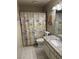 Cozy bathroom with a patterned shower curtain, granite countertop, and decorative sunflower art at 2484 Domingo St, Las Vegas, NV 89121