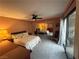 Cozy bedroom with a ceiling fan, mirrored closet, and a view to an outdoor patio area at 2484 Domingo St, Las Vegas, NV 89121