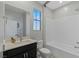 This bathroom features a shower-tub combo with white tile and a vanity with dark cabinets and neutral countertop at 2518 Veronella St, Henderson, NV 89044