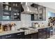 This kitchen features modern stainless steel appliances, dark cabinets, wine cooler and a patterned backsplash at 2518 Veronella St, Henderson, NV 89044