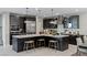 A well-lit kitchen featuring an island with barstool seating, stainless appliances, and dark modern cabinetry at 2518 Veronella St, Henderson, NV 89044