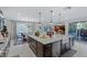 Gourmet kitchen boasts a large island, farm sink, stainless appliances, and opens to a dining area and outdoor patio at 2518 Veronella St, Henderson, NV 89044