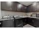 Well-appointed laundry room features front loading washer and dryer and ample cabinet space at 2518 Veronella St, Henderson, NV 89044