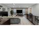 View of open living room with modern decor, large TV, and staircase with dark wood railing at 2518 Veronella St, Henderson, NV 89044