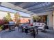 Relax in this outdoor living space with a grill, fire pit, and comfortable seating underneath the pergola at 2518 Veronella St, Henderson, NV 89044