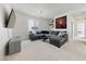 The living room boasts a grey sectional, TV, and entertainment center with bright natural light at 2606 Marvel Astoria St, Henderson, NV 89044