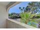 A balcony view of a backyard with a pool, palm trees, and a quaint home in the background at 2771 S Buffalo Dr, Las Vegas, NV 89117