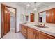 Bathroom featuring a tile countertop, double sinks, wood cabinets and a view of the shower at 2771 S Buffalo Dr, Las Vegas, NV 89117