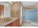 Bathroom featuring a tiled countertop, wood cabinets, and a shower with glass doors at 2771 S Buffalo Dr, Las Vegas, NV 89117