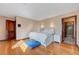 Bedroom with hardwood floors, white bed with a cozy blue rug, and view to ensuite bathroom at 2771 S Buffalo Dr, Las Vegas, NV 89117