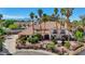 Expansive home featuring a clay tile roof, lush landscaping, and mature palm trees at 2771 S Buffalo Dr, Las Vegas, NV 89117