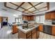 Spacious kitchen featuring wood cabinets, a tiled island cooktop, and white tiled flooring for a classic design at 2771 S Buffalo Dr, Las Vegas, NV 89117