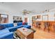 Bright living room featuring hardwood floors, a comfortable blue sofa, and a wooden bar for entertaining guests at 2771 S Buffalo Dr, Las Vegas, NV 89117