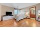 Comfortable main bedroom with hardwood flooring, bright light from window, and an ensuite bathroom at 2771 S Buffalo Dr, Las Vegas, NV 89117