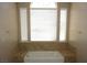 Modern bathtub with tiled surround and large window, offering a spa-like experience in a well-lit space at 2830 Queens Courtyard Dr, Las Vegas, NV 89109