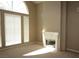 Bright living room with a fireplace, a large window and neutral color palette, creating a warm and inviting atmosphere at 2830 Queens Courtyard Dr, Las Vegas, NV 89109