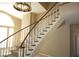 Elegant carpeted staircase with a wooden handrail leads to the upper level, enhanced by natural light at 2830 Queens Courtyard Dr, Las Vegas, NV 89109