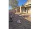 A view of the backyard, featuring desert landscaping, rock covering, and a covered patio area at 2839 Kensington St, Las Vegas, NV 89156